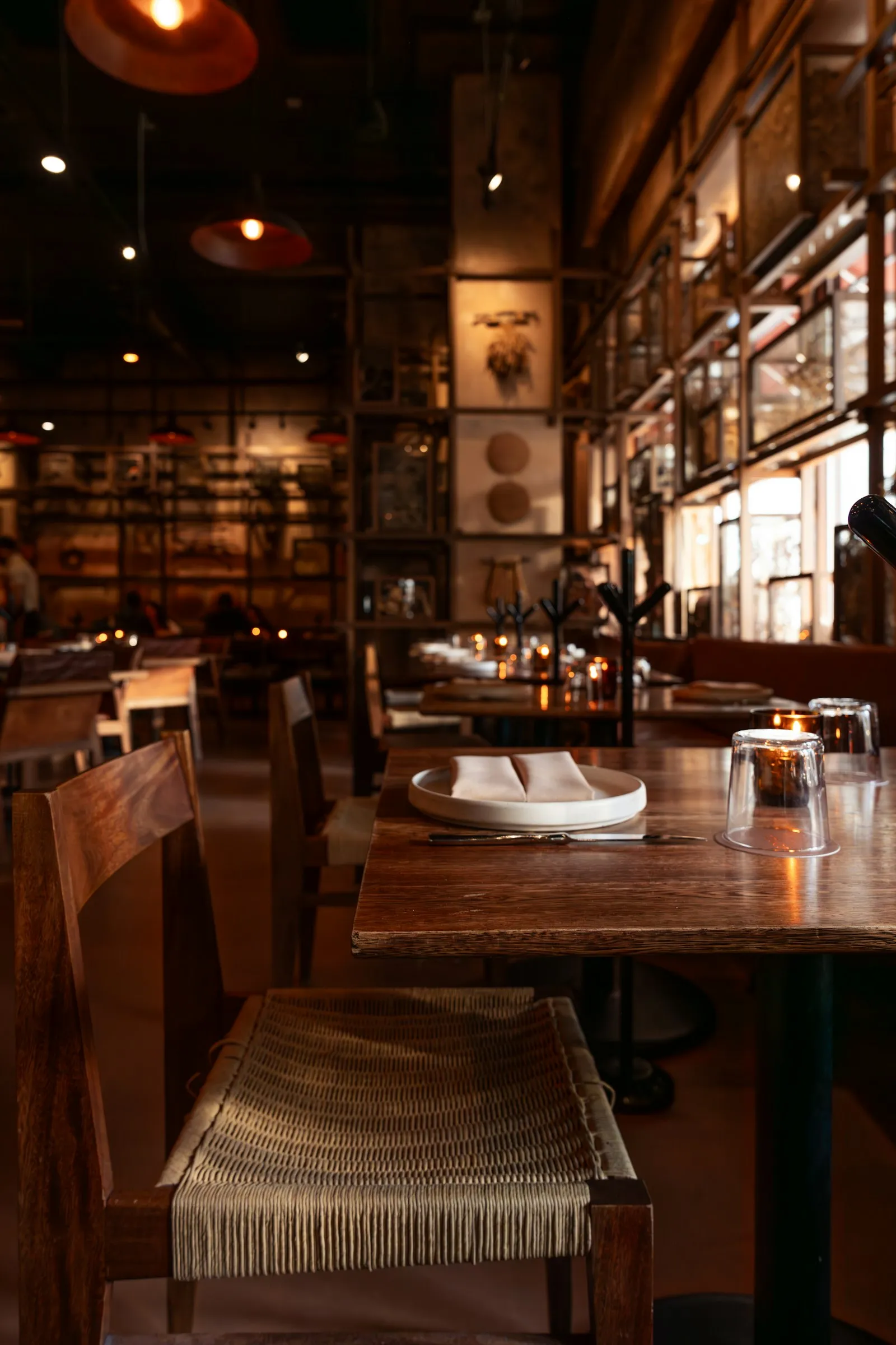 Mesas de madera de un restaurante preparadas para el servicio
